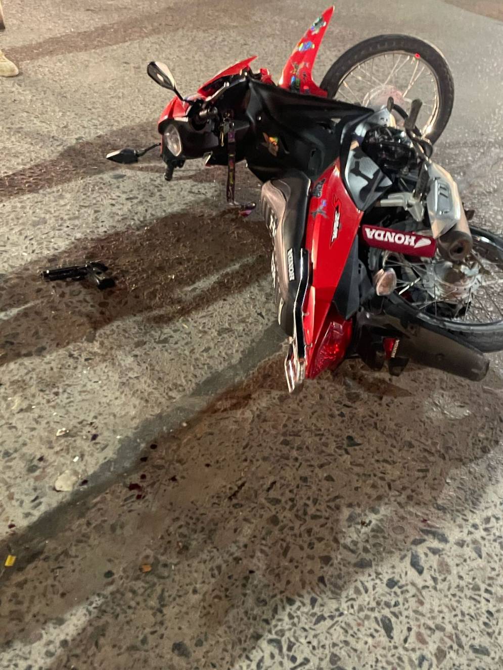 La moto y la pistola de utilería, en el asfalto de Avenida Libertad y 25 de Mayo. 