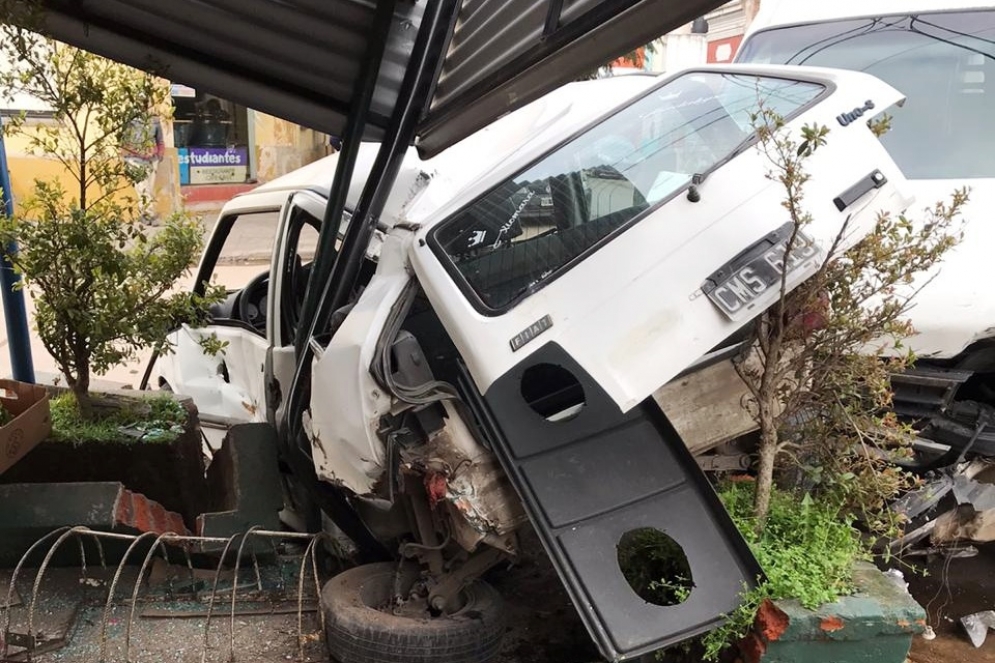 El Fiat 1 atrapado entre el cantero y la trompa de la camioneta.