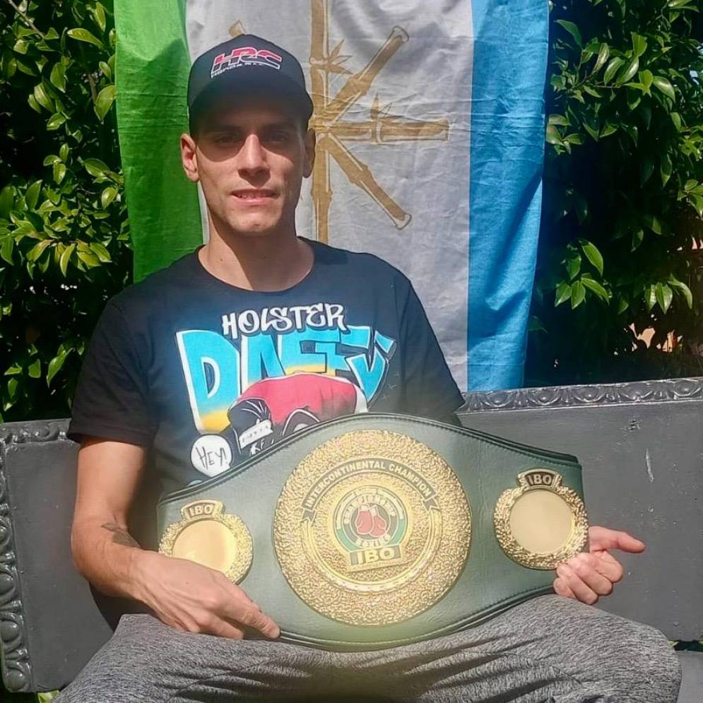 El campeón posa con la corona y la bandera de Cañuelas.