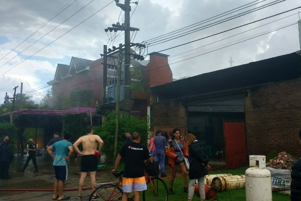 La gente observando el accionar de los bomberos a metros de las garrafas de gas que ya estaban a salvo en la vereda. (FOTO: Germán Senas).